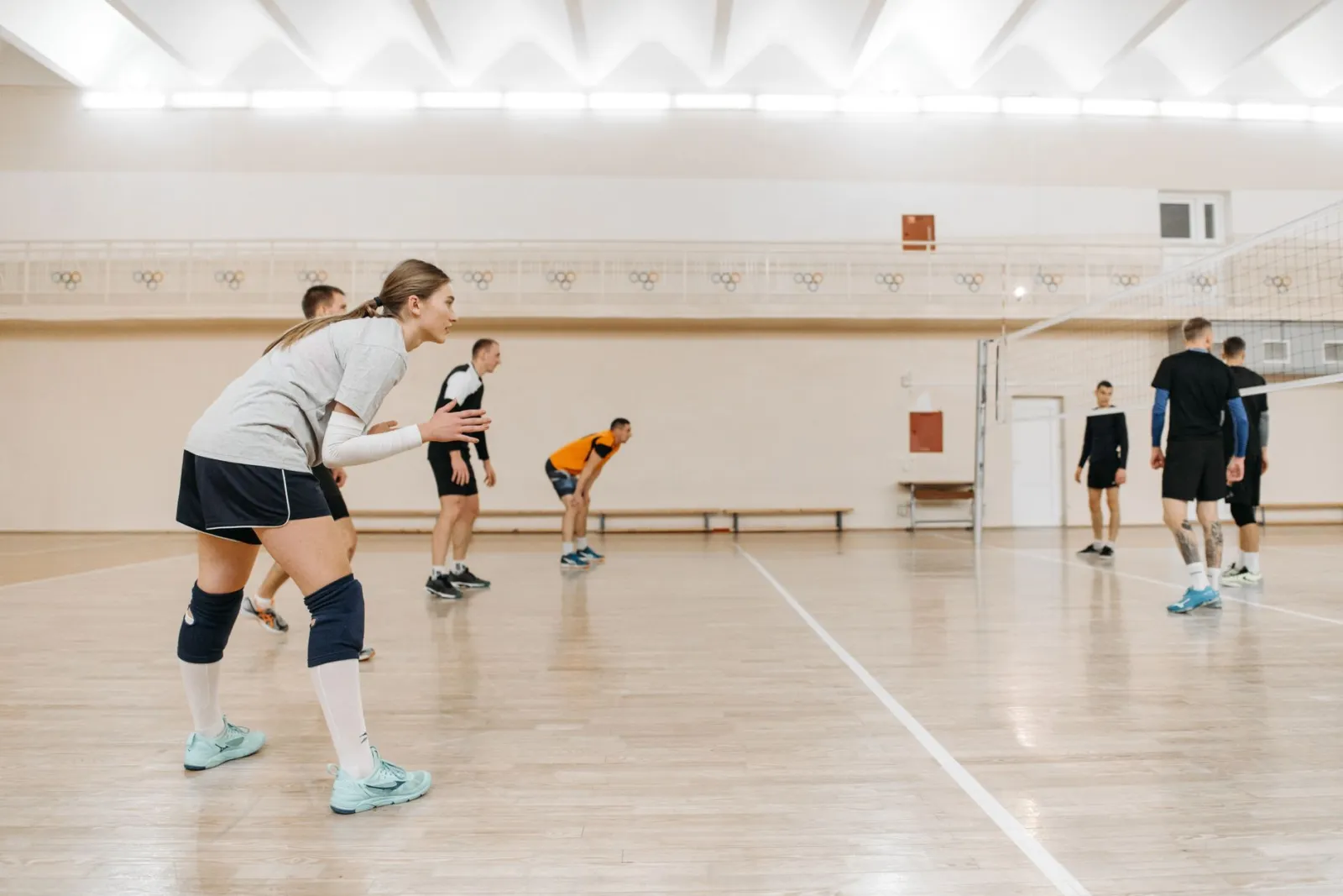 Athletes playing an intense volleyball match indoors, showcasing teamwork and sportsmanship.